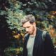 selective focus photography of man standing near tree