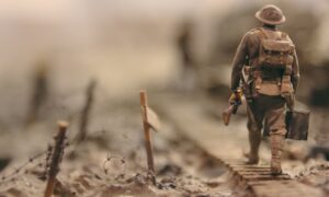 soldier walking on wooden pathway surrounded with barbwire selective focus photography