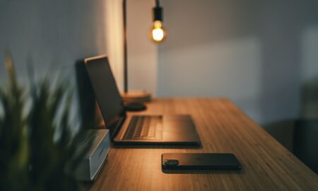 black laptop computer on brown wooden table