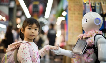 photo of girl laying left hand on white digital robot