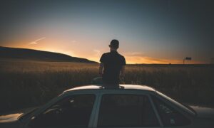 man sitting on gray sedan