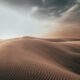 sand dunes at desert under grey cloudy sky