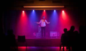 man in black shirt singing on stage