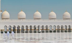 Three Men Walking in Front of a Dome Building