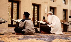 a couple of men sitting on top of a floor